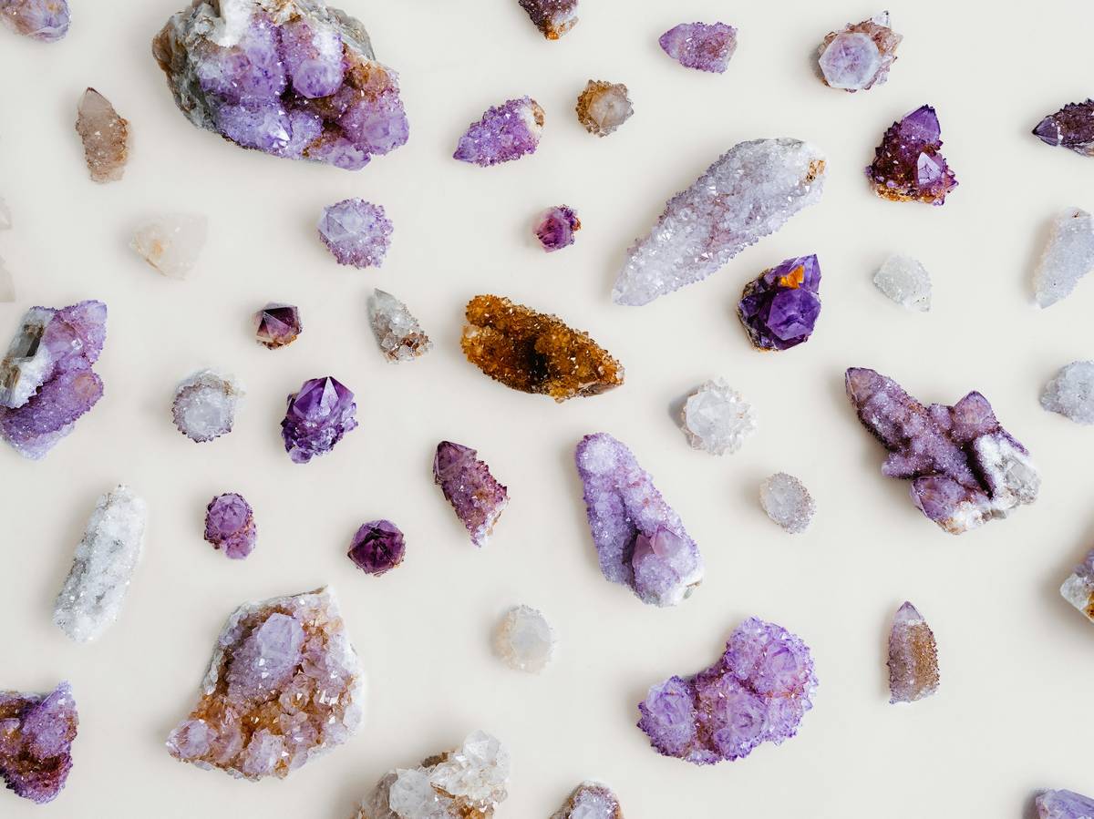 real healing crystals and stones arranged on a linen cloth with natural light highlighting their raw textures and earthy tones