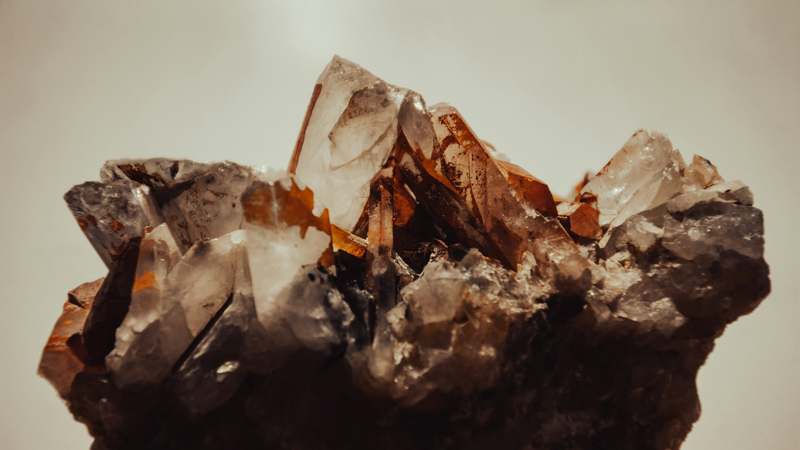 Woman holding raw organic crystals with glowing skin in natural sunlight